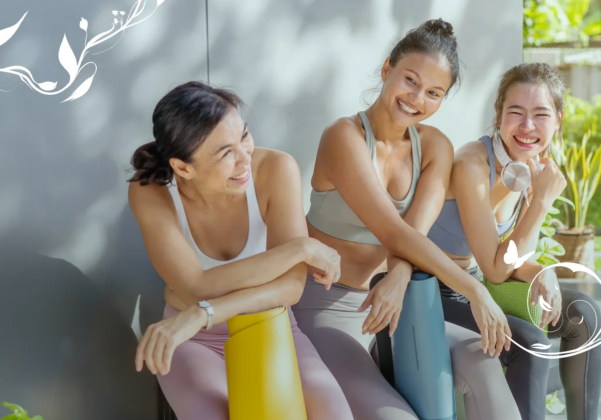Three women smiling with yoga mats, representing gynaecology care.